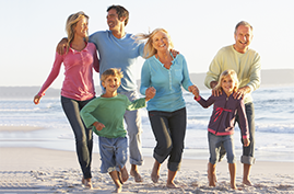 Eltern, Großeltern und zwei Kinder fröhlich am Strand